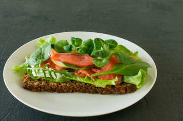 Sandwich with smoked salmon soft cheese, lattice and lemon. Concept for a tasty and healthy meal. Food on a plate.