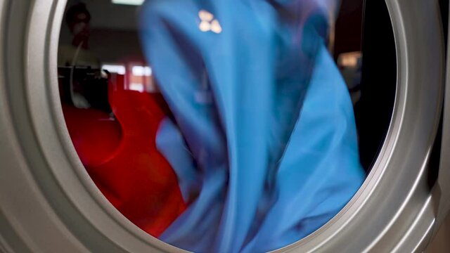 Industrial dryer machine working close-up of drying clothes in drying machine close up.