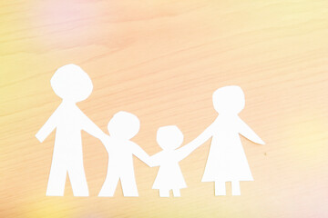 family made of paper, a symbol of a happy strong family, on wooden background. children's Day, family day.