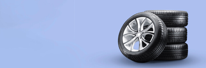 summer tires and wheels-stack on blue background, new wheels long blank layout copyspace - obrazy, fototapety, plakaty