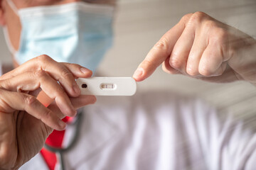 Male Doctor touching positive covid-19 test stick, coronavirus prevention of pandemic concept