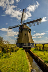 Schoorl, the Netherlands, April 2021. A traditional Dutch windmill with a thatched roof. Dutch landscape. © Bert