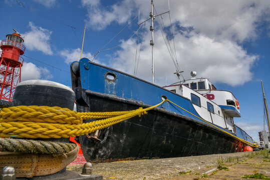 Den Helder, the Netherlands, April 2021. A tugboat moored at the quay of Willemsoord, a former shipyard in the habor of Den Helder, the Netherlands. Low angle.