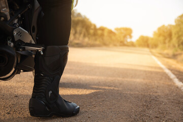 Close-up of a biker's boot on the road. concept road safety and personal protective equipment