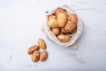 Raw fresh organic potatoes. Full bag of potatoes. Burlap sack with potatoes. Space for text