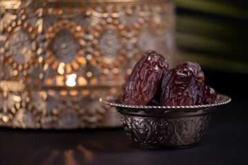 Ramadan Kareem, Dried dates on traditional candlelight background with copy space. Religious Islamic celebration of the holy month of Eid Mubarak concept.  