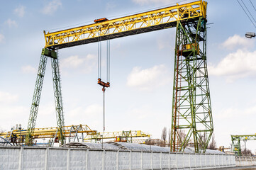 Fototapeta na wymiar Large industrial crane. Crane for lifting large loads. The crane is behind the fence.