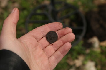 old coin in the hand of an archaeologist