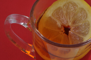 Tasse de thé au citron en gros plan sur fond rouge