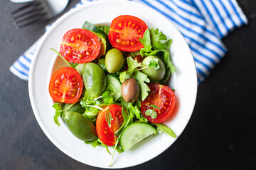 salad vegetable olives tomato cucumber, lettuce mix leaves snack meal diet vegan or vegetarian food copy space food background rustic. top view 