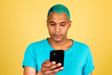 Black african man in casual on yellow background with mobile phone serious face look on screen read news