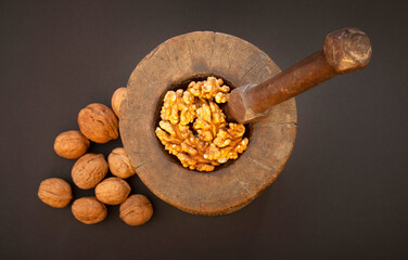 Walnuts in antique, wooden mortar.