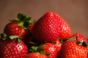 Strawberries macro. Fresh ripe red strawberries on brown background. 