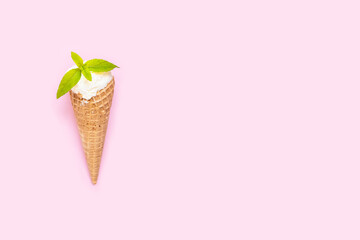 Vanilla ice cream cone with mint on pink background. Copy space. Minimal summer background.