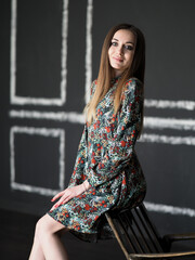 Dramatic portrait of a brunette girl in cold light in a dress