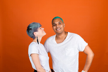 Black african man and european woman in casual white on orange background happy and positive emotions