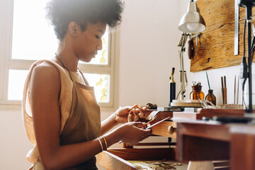 Woman with jewelry and tool in her hands in workshop