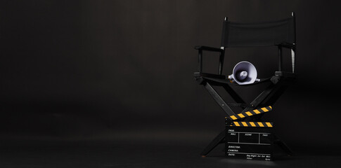 Black director chair and Clapper board or movie Clapperboard with yellow megaphone on black background.use in video production or film cinema industry - obrazy, fototapety, plakaty
