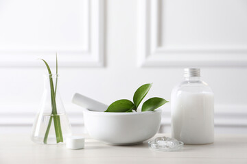 Natural ingredients for cosmetic products and laboratory glassware on white table