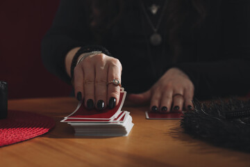 Soothsayer predicting future with cards at table indoors, closeup