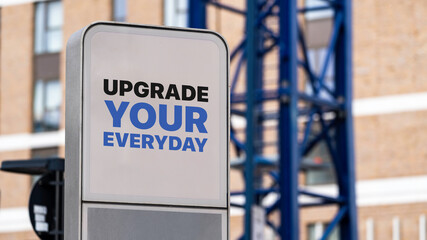 Upgrade Your Everyday sign in a city setting under construction 