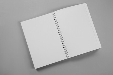 Open blank notebook on grey background, top view. Mockup for design