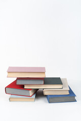 Book stack, hardback colorful books on wooden table, white background. Back to school. Copy space for text. Education business concept.
