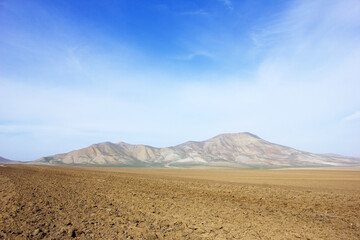 Mountains begin at the end of the field. Gobustan region. Azerbaijan.