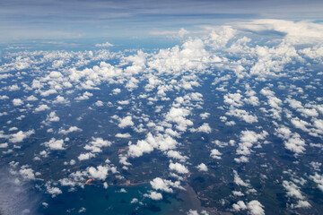 Blue sky with fluffy clouds. Airplane flying in cloudy over blue sky. Beautiful view seen from the plane.