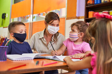 Tagesmutter und Kinder mit Gesichtsmaske in Vorschule