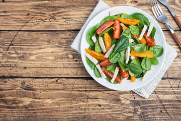 Salad of boiled squid, fresh tomatoes, spinach leaves. Delicious bright diet dish with vegetables and seafood. Copy space top view