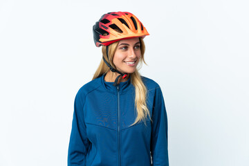 Young blonde Uruguayan cyclist woman isolated on background looking side