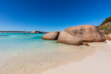 Landscape view of the pristine white sands, crystal clear aqua water and granite boulders on a clear blue day at Twilight Cove, near Esperance in Western Australia.