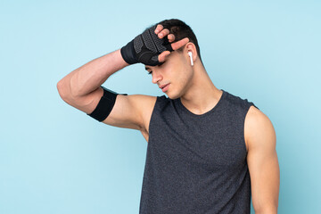 Young sport man over isolated on blue background with tired expression