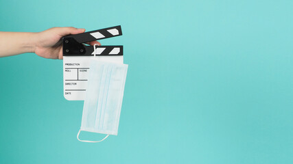 Fack mask on clapperboard and hand is holding clapper board or movie slate.It is used in film...
