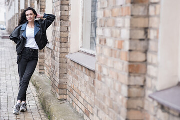 Fototapeta na wymiar Portrait of a beautiful brunette girl who poses while walking on the street