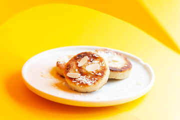 Tofu cheese pancakes on a plate on a yellow and orange background. Vegan food, sugar, gluten and lactose free. 
