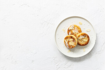 Tofu cheese pancakes on a plate on a light background. Vegan food, sugar, gluten and lactose free. Horizontal orientation, top view, copy space.