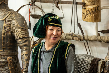 woman in national skullcap and vest on the background of vintage metal wars 