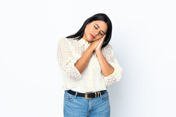 Young latin woman woman isolated on white background making sleep gesture in dorable expression