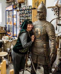 woman in national skullcap and vest on the background of vintage metal wars 