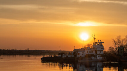 Fototapeta premium Dredger is working to deepen the fairway on the river. Cleaning and deepening by a dredger on the river. Sunset on the river. Industrial concept.