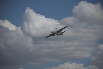Fototapeta na wymiar Historic airplane flying through the clouds