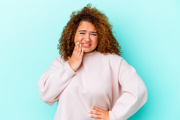 Young latin curvy woman isolated on blue background having a strong teeth pain, molar ache.