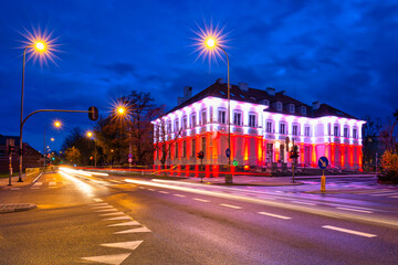 Fototapeta na wymiar Red and white illumination at the Constitution Day on May 3 on the City Hall building in Pruszcz Gdański. Poland