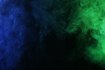 Smoke in blue green light on black background
