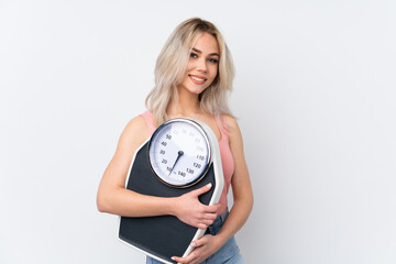 Teenager girl over isolated white background with weighing machine