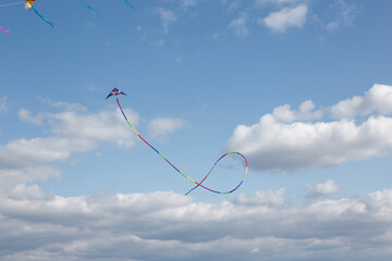 Flying kite against background blue sky with cloud.