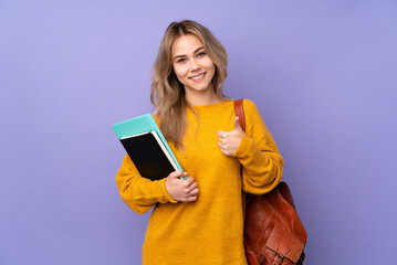 Teenager Russian student girl isolated on purple background giving a thumbs up gesture - obrazy, fototapety, plakaty