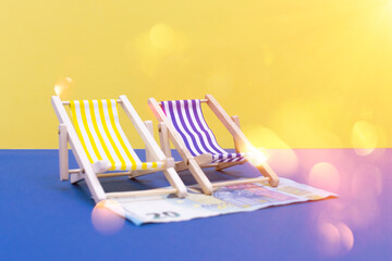 Banknote put on the ground as a rug, towel, mat, cloth, sheet, under loungers, hammocks or beach chairs on blue and yellow isolated background with sun glare or bokeh